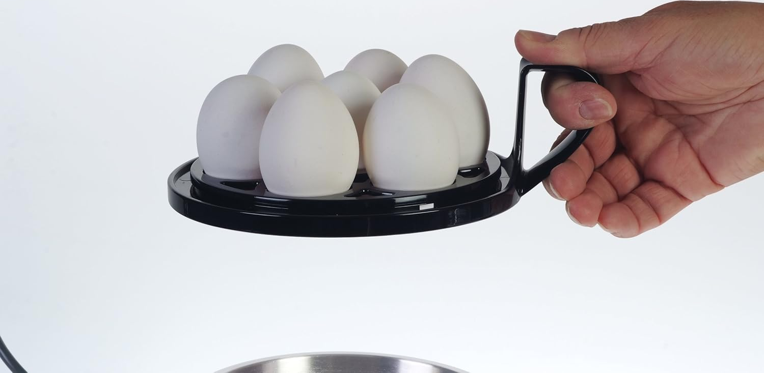 Una mano che tiene un portauova nero con sei uova bianche, su uno sfondo bianco.