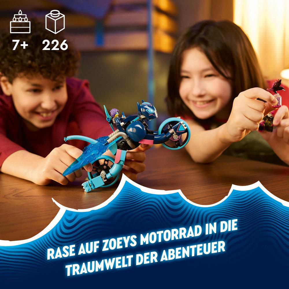 Zwei Kinder spielen mit einem Spielzeugmotorrad und lächeln.