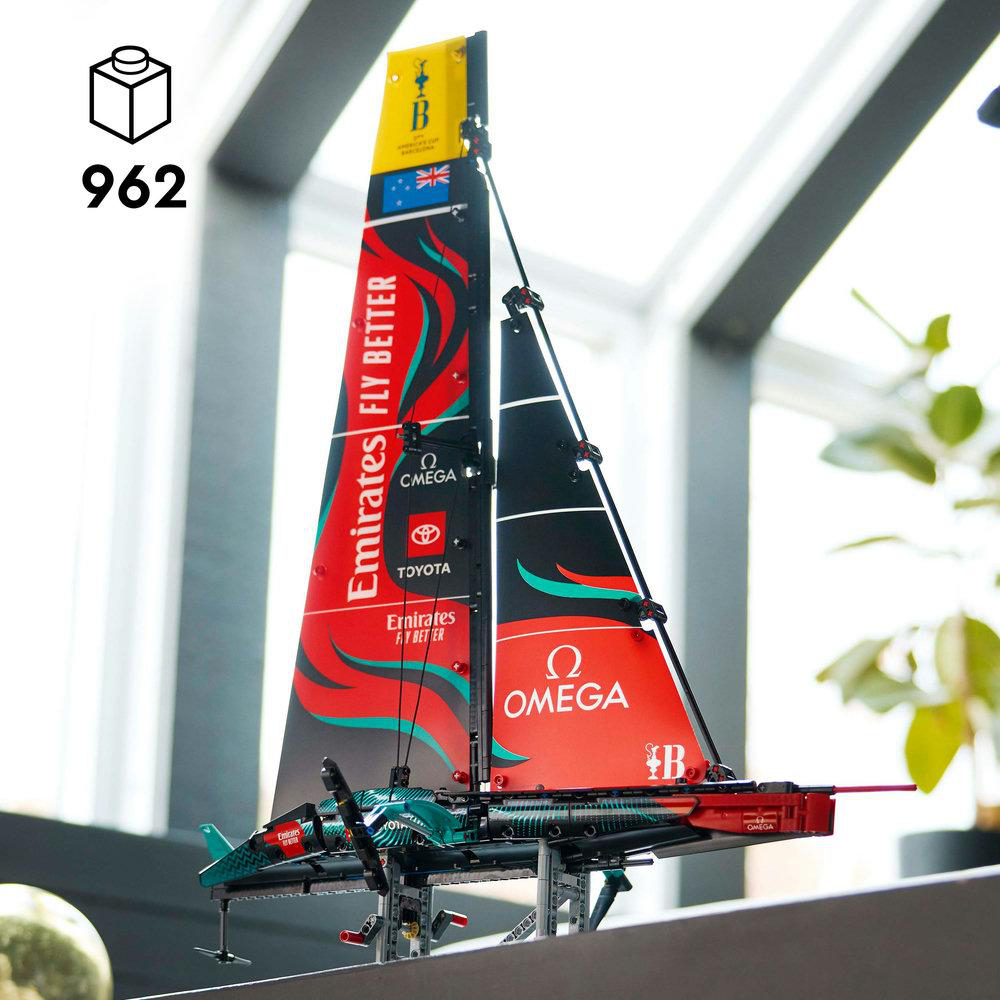 Lego-Segelbootmodell mit roten, schwarzen und weißen Segeln. Das Modell steht vor einem Fenster.