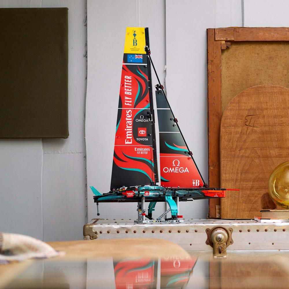 Ein Lego-Modell eines Segelbootes. Es steht auf einem Holztisch mit hellgrauem Hintergrund.