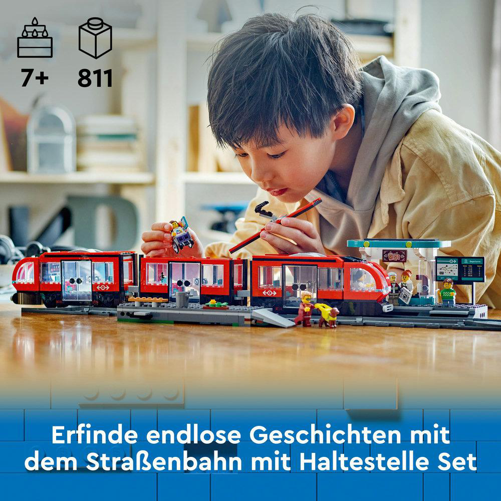 Junge spielt mit einem Lego-Zug-Set, rot und weiß.