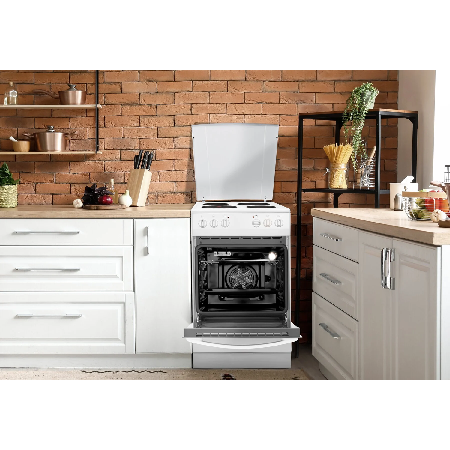 Four blanc avec porte ouverte, dans une cuisine avec mur de briques.