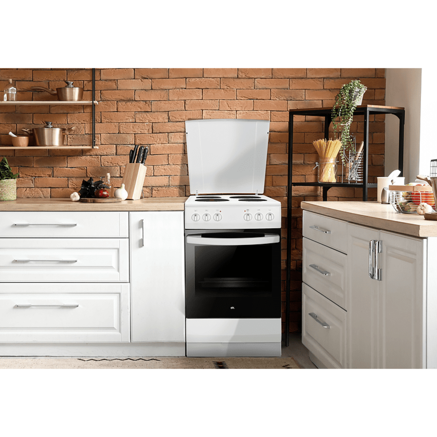 Cuisinière autonome blanche et argentée dans un cadre de cuisine.