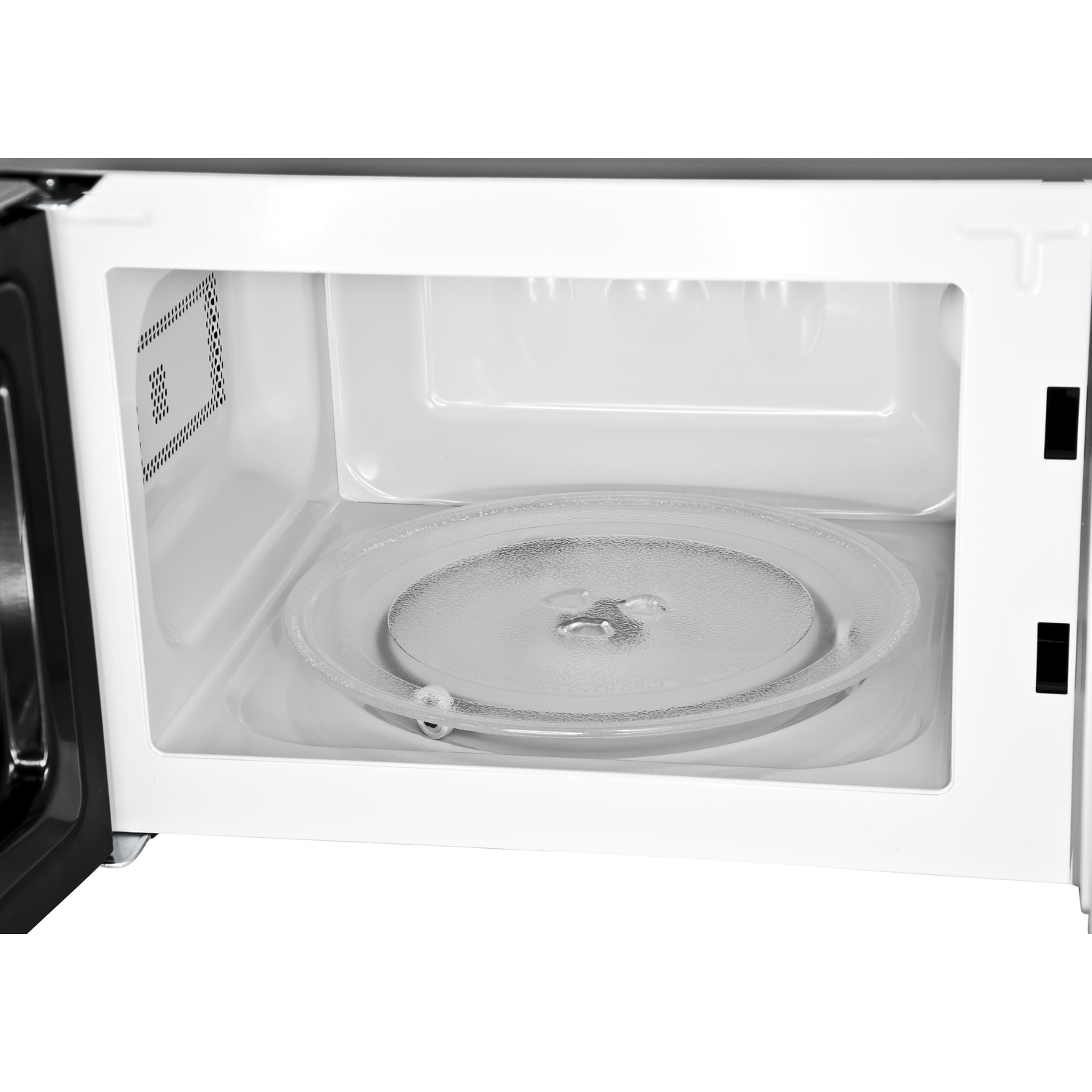 A microwave interior with a glass plate. White interior with an open door.