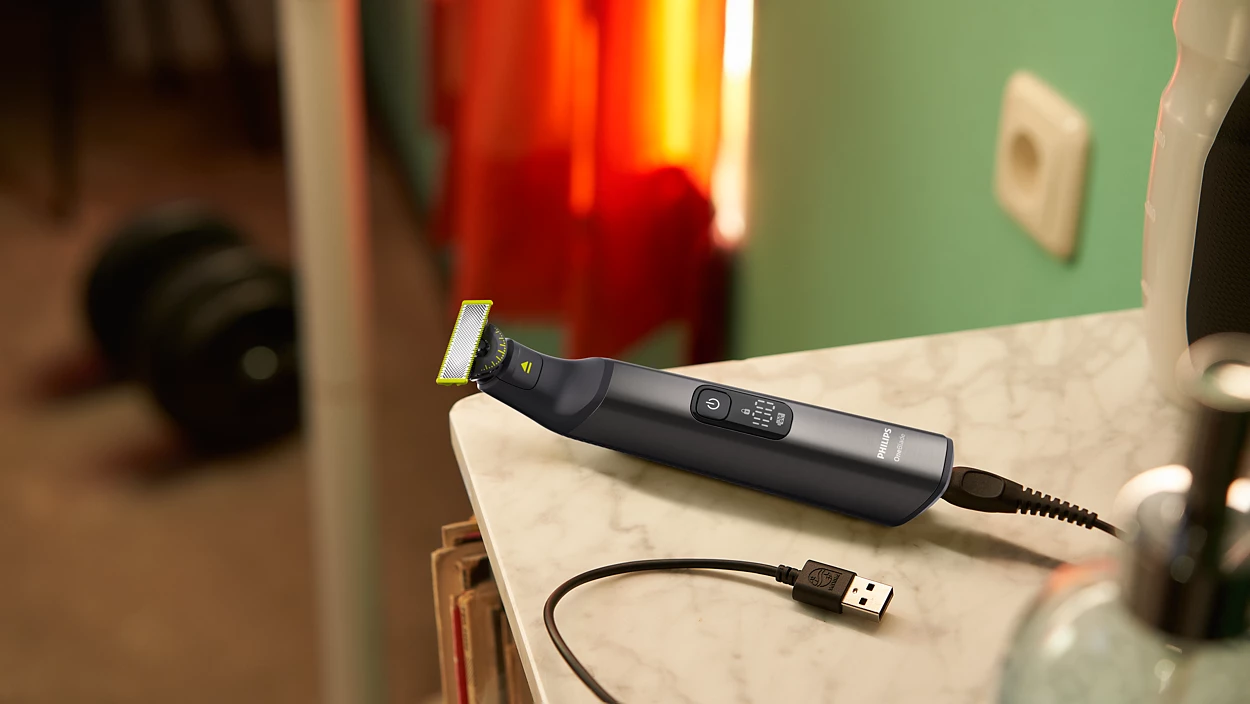 Schwarzer Philips Barttrimmer, Ladekabel und USB-Anschluss auf einem Tisch.