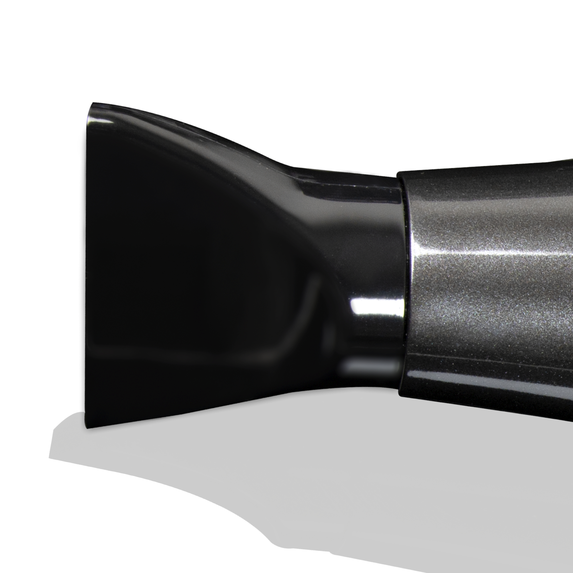 Zbliżenie czarnej nasadki do suszarki do włosów. Białe tło. Obecny jest cień.