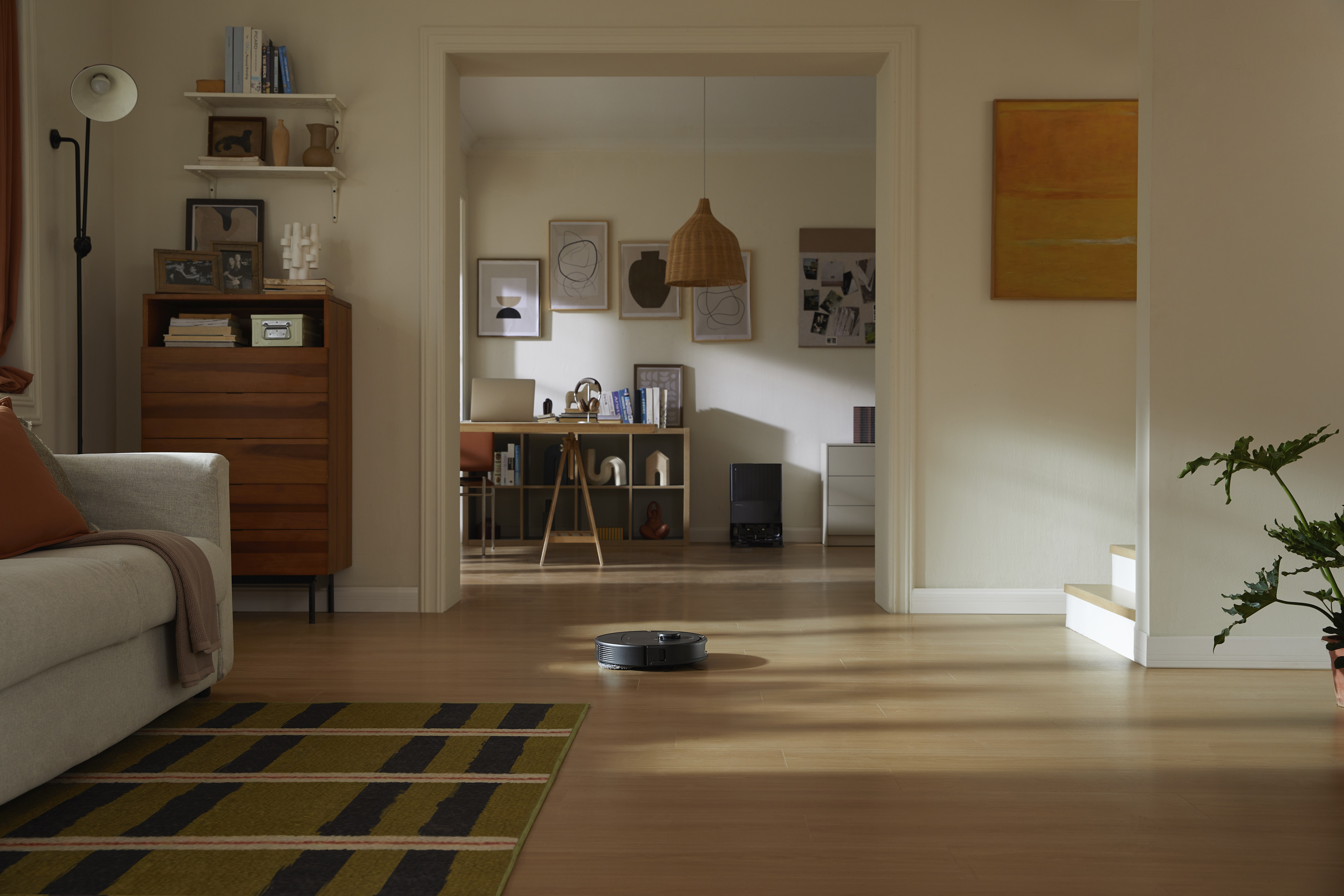 Nowoczesny salon z robotem sprzątającym na podłodze.
