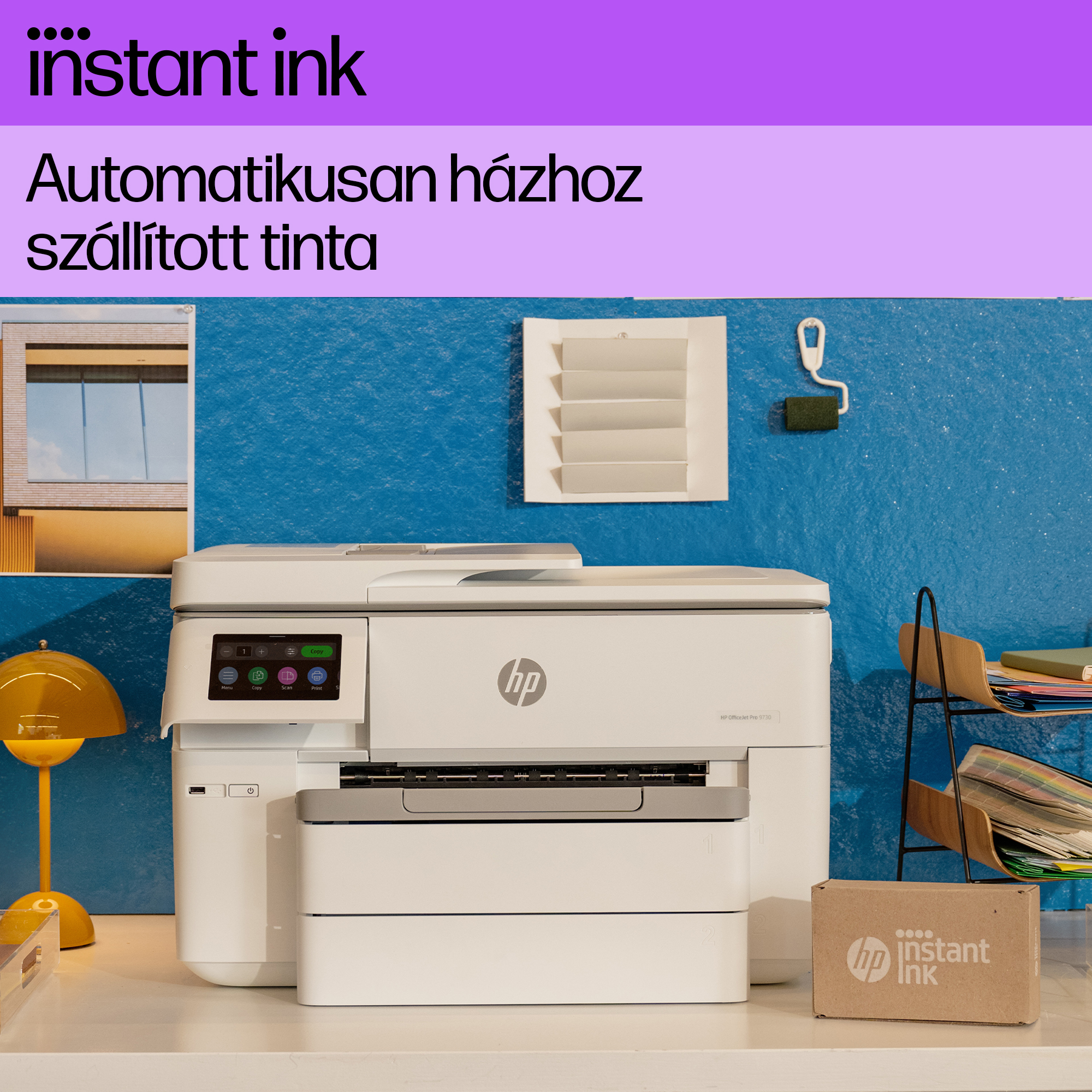 HP nyomtató az asztalon, kék fal háttérrel és azonnali tintadobozzal.
