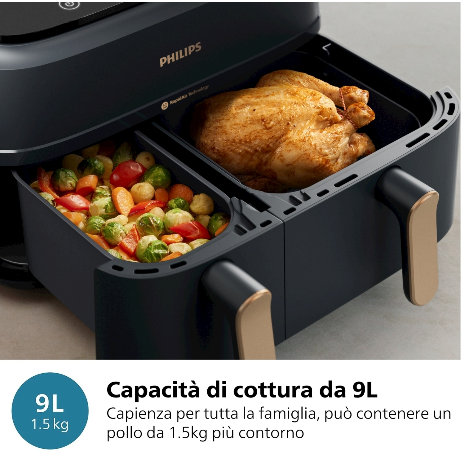 Una friggitrice ad aria nera con due scomparti, uno con pollo cotto e l'altro con verdure.