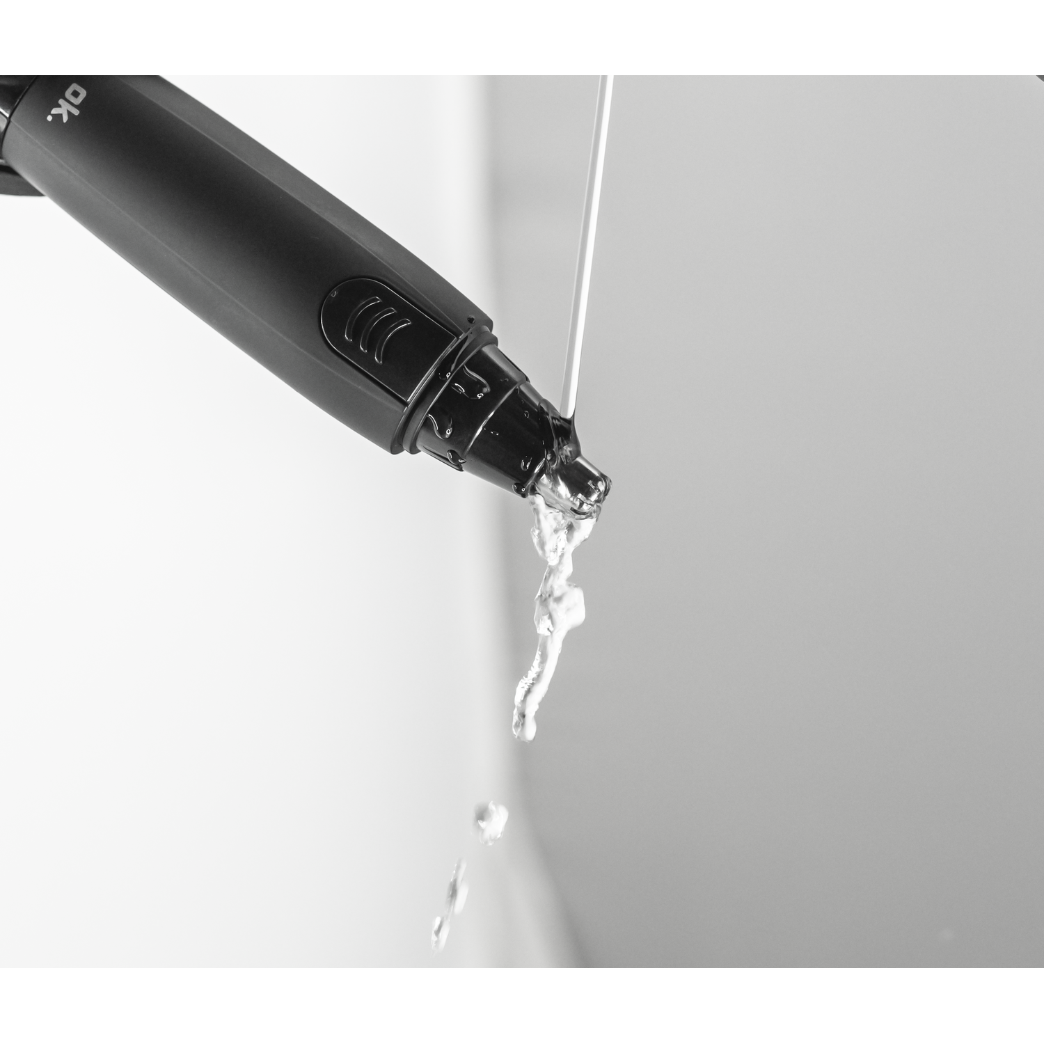 Een zwart apparaat giet water. Witte achtergrond.