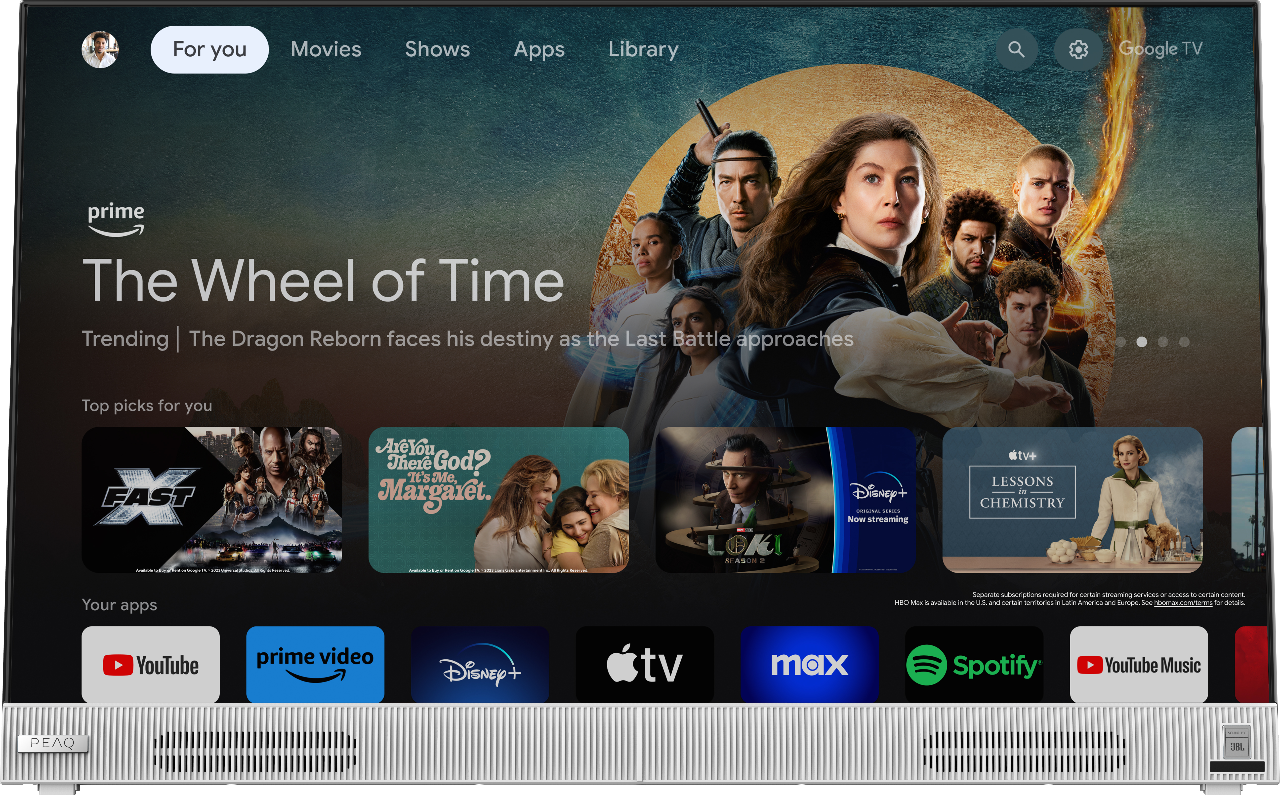 TV-Bildschirm zeigt Google TV-Oberfläche mit Streaming-Apps und Filmpostern.