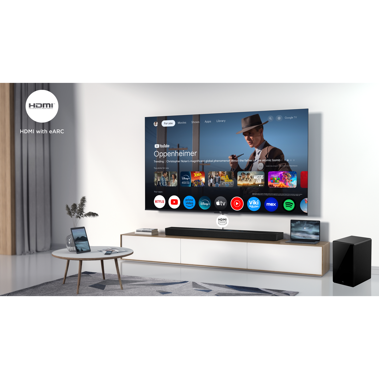 A living room with a TV showing Oppenheimer. A soundbar, subwoofer, and a laptop are in front.