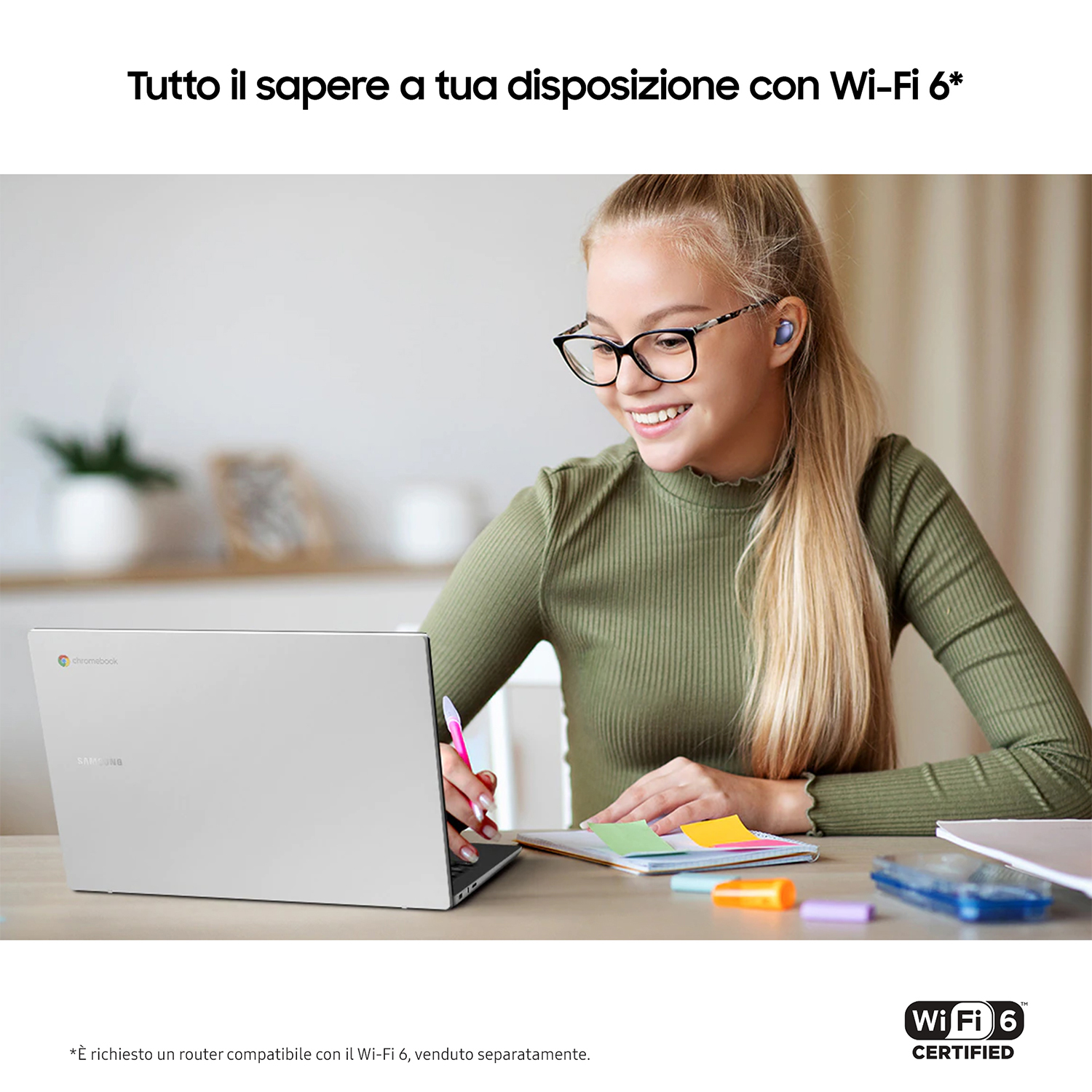 Giovane donna con occhiali, usa un laptop argentato, con auricolari.