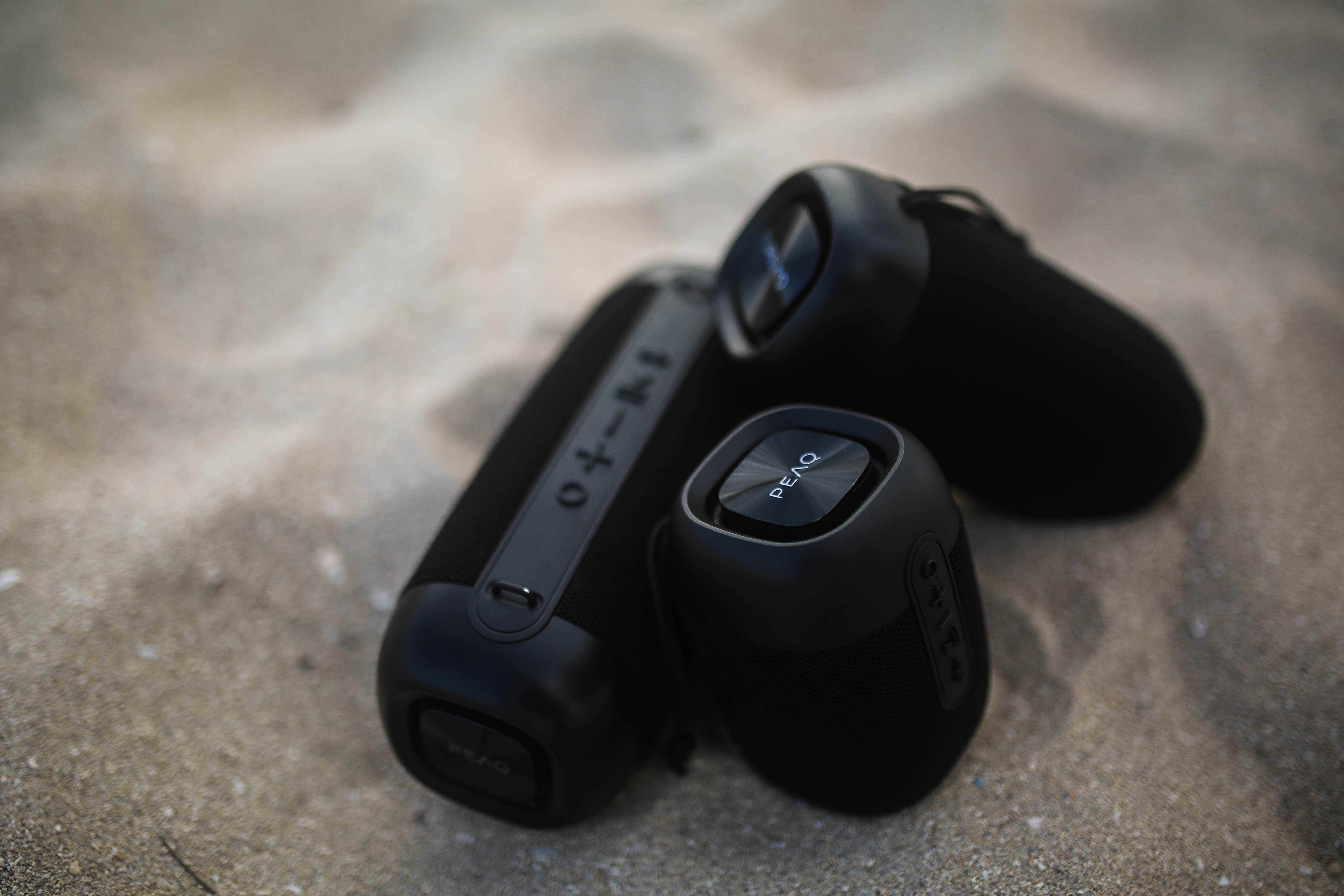 Czarne głośniki na piaszczystej plaży.