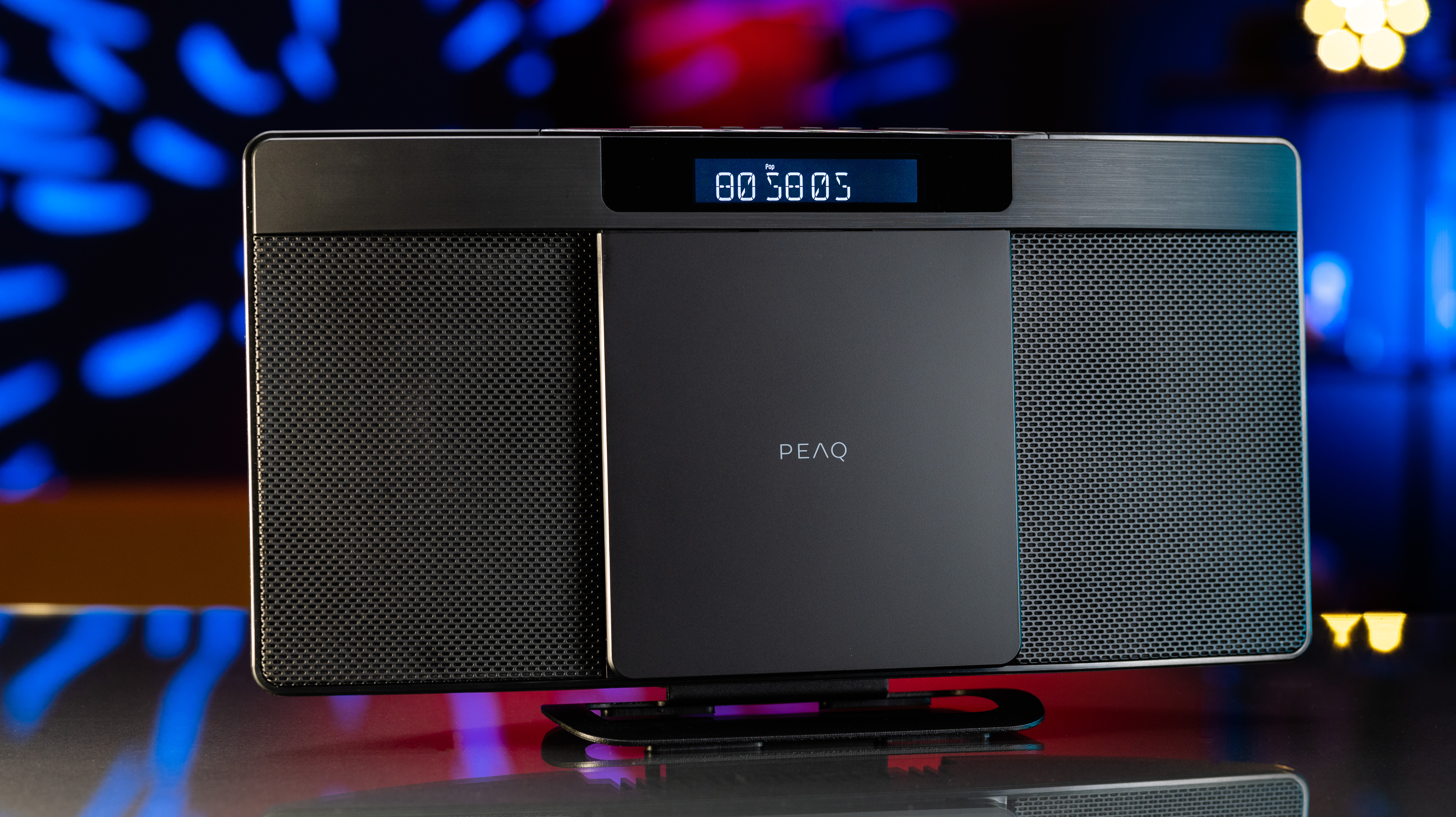 Czarny system dźwiękowy PEAQ. System ma głośniki i wyświetlacz pokazujący czas.