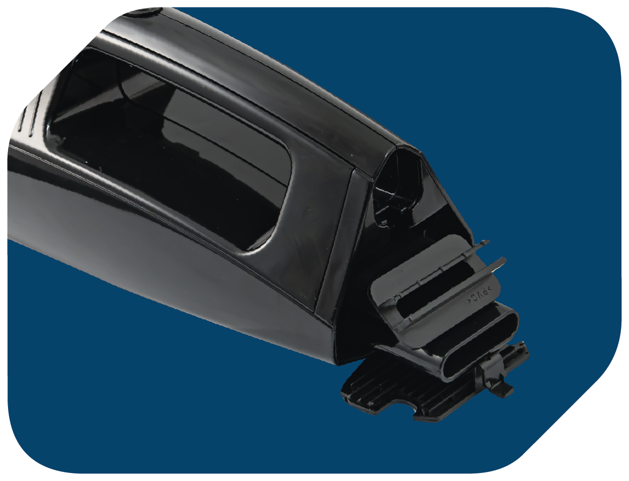 Czarna plastikowa część z przegrodą i małym otworem. Otwór ma plastikową pokrywę.