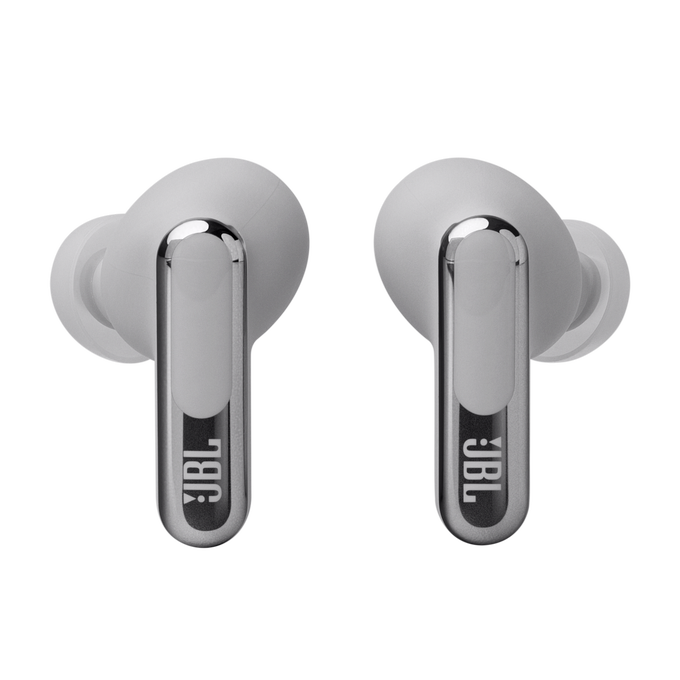 Par de auriculares inalámbricos JBL, color gris claro, con detalles plateados. Fondo negro.