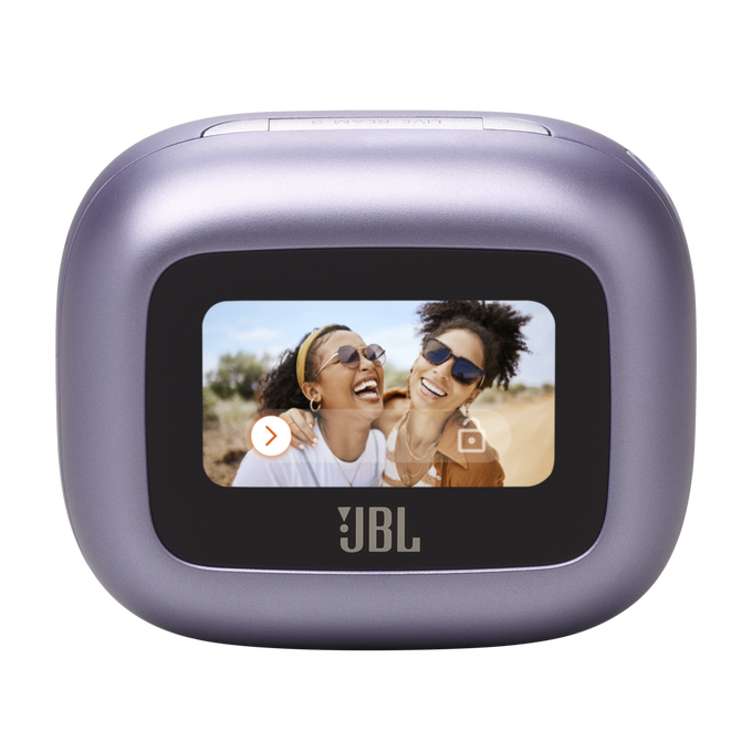 Una cámara JBL morada con pantalla. Dos mujeres se ríen en la pantalla, en un entorno al aire libre.