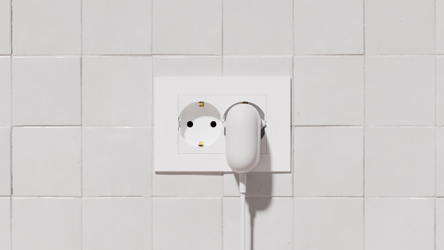 Un enchufe eléctrico blanco con un enchufe blanco insertado, sobre un fondo de azulejos blancos.
