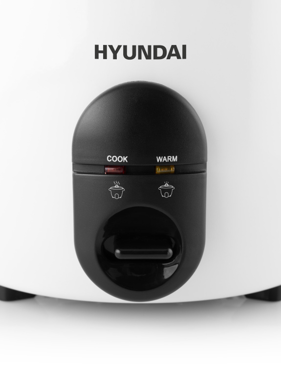 Fehér Hyundai rizsfőző közelről. Fekete vezérlőpanel 'Cook' és 'Warm' opciókkal. Logók és gomb láthatók.