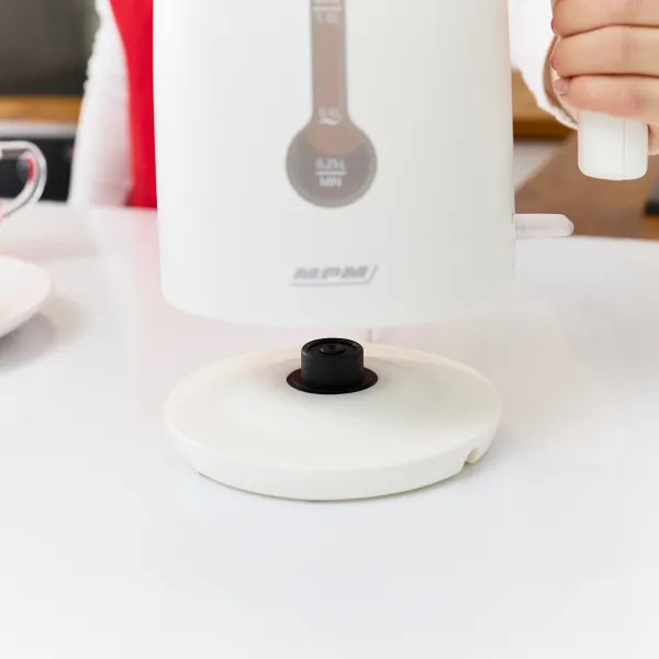 Biały czajnik na białej powierzchni, z widoczną podstawą.