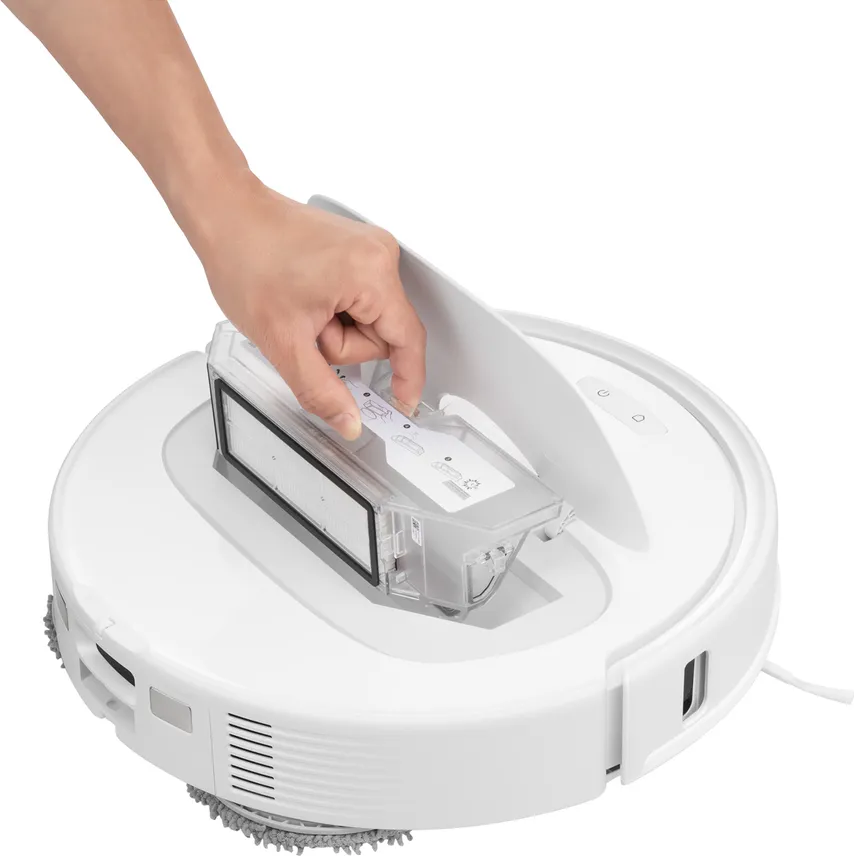 La mano inserisce e rimuove un contenitore trasparente in un aspirapolvere robotico bianco.