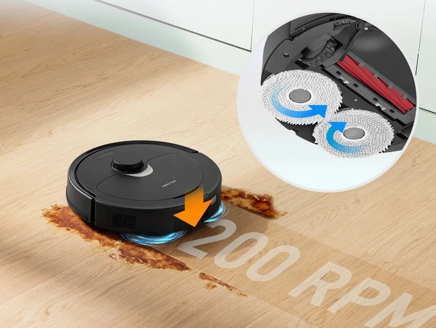 Ein Roboter-Staubsauger reinigt einen Holzboden mit braunen Flecken.