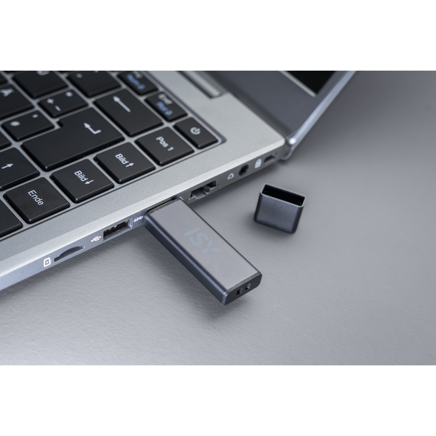 Ordinateur portable avec une clé USB insérée. La clé est grise, avec le logo ISY visible, près du clavier.