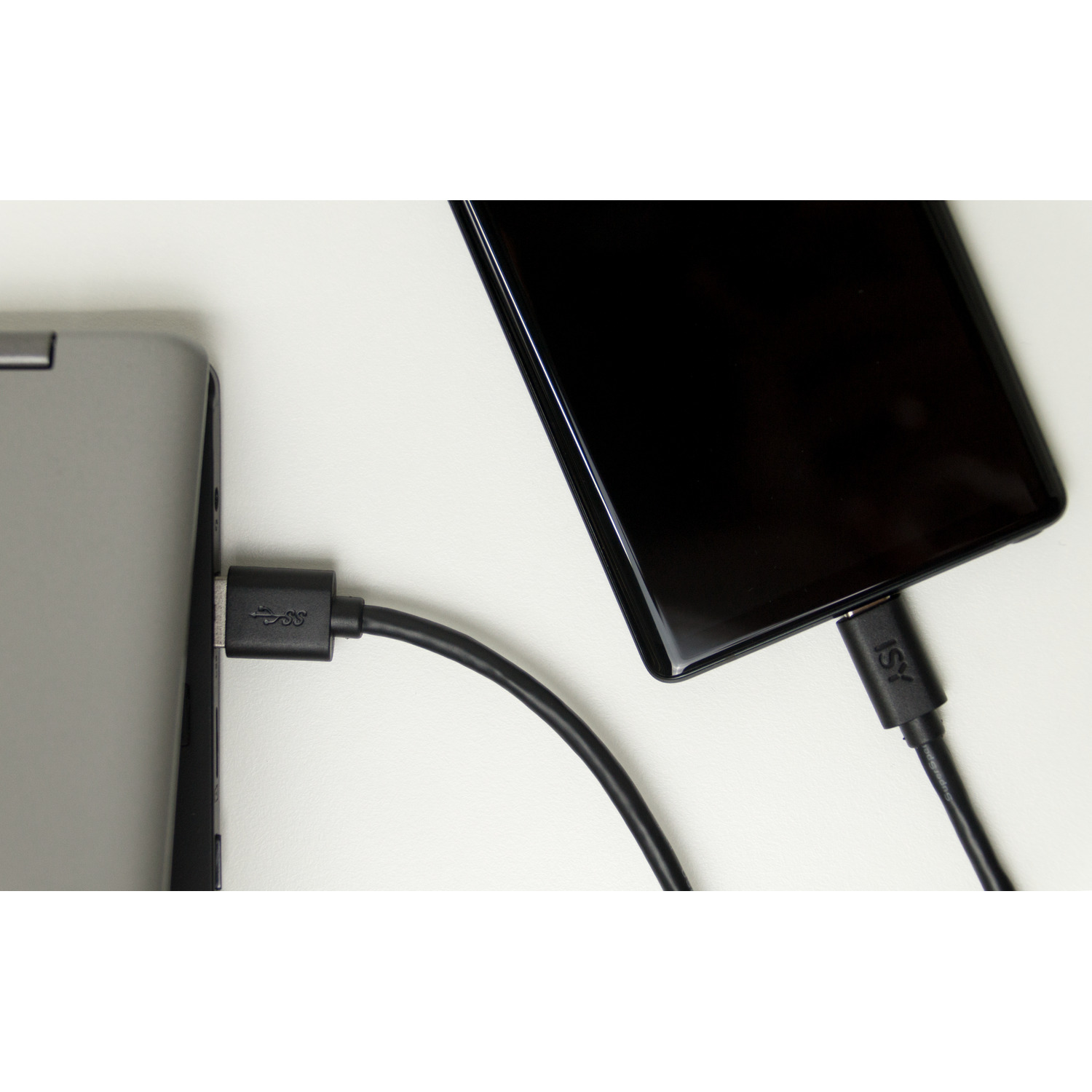 A laptop connected to a phone with a USB cable. The laptop is silver, the phone is black.