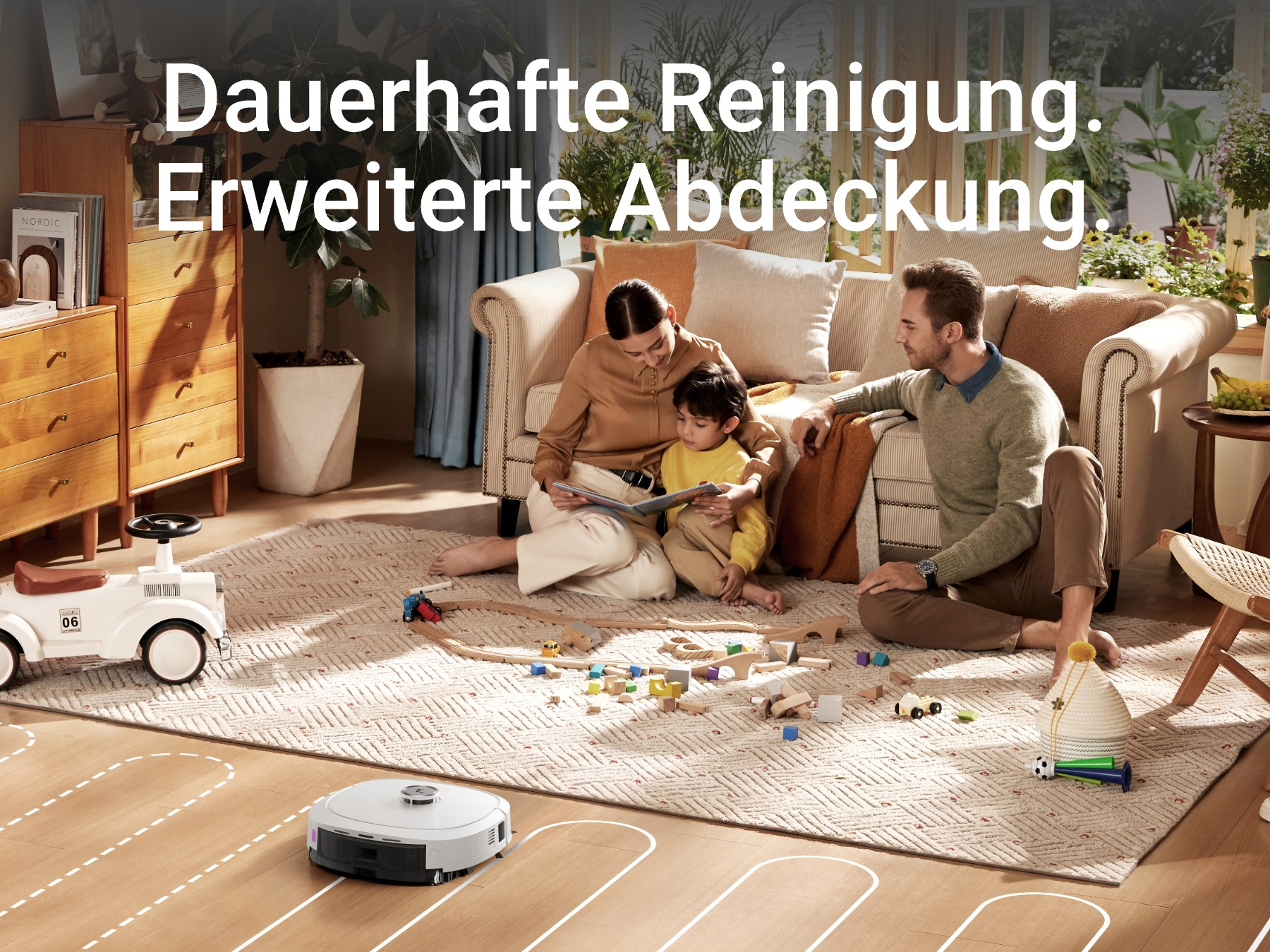 Familie liest im Wohnzimmer mit einem Roboterstaubsauger. Der Roboter reinigt den Boden.