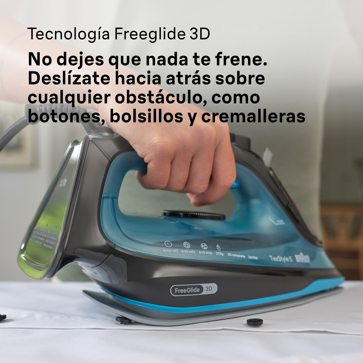 Tabla de planchar con plancha azul y negra, planchando ropa blanca.