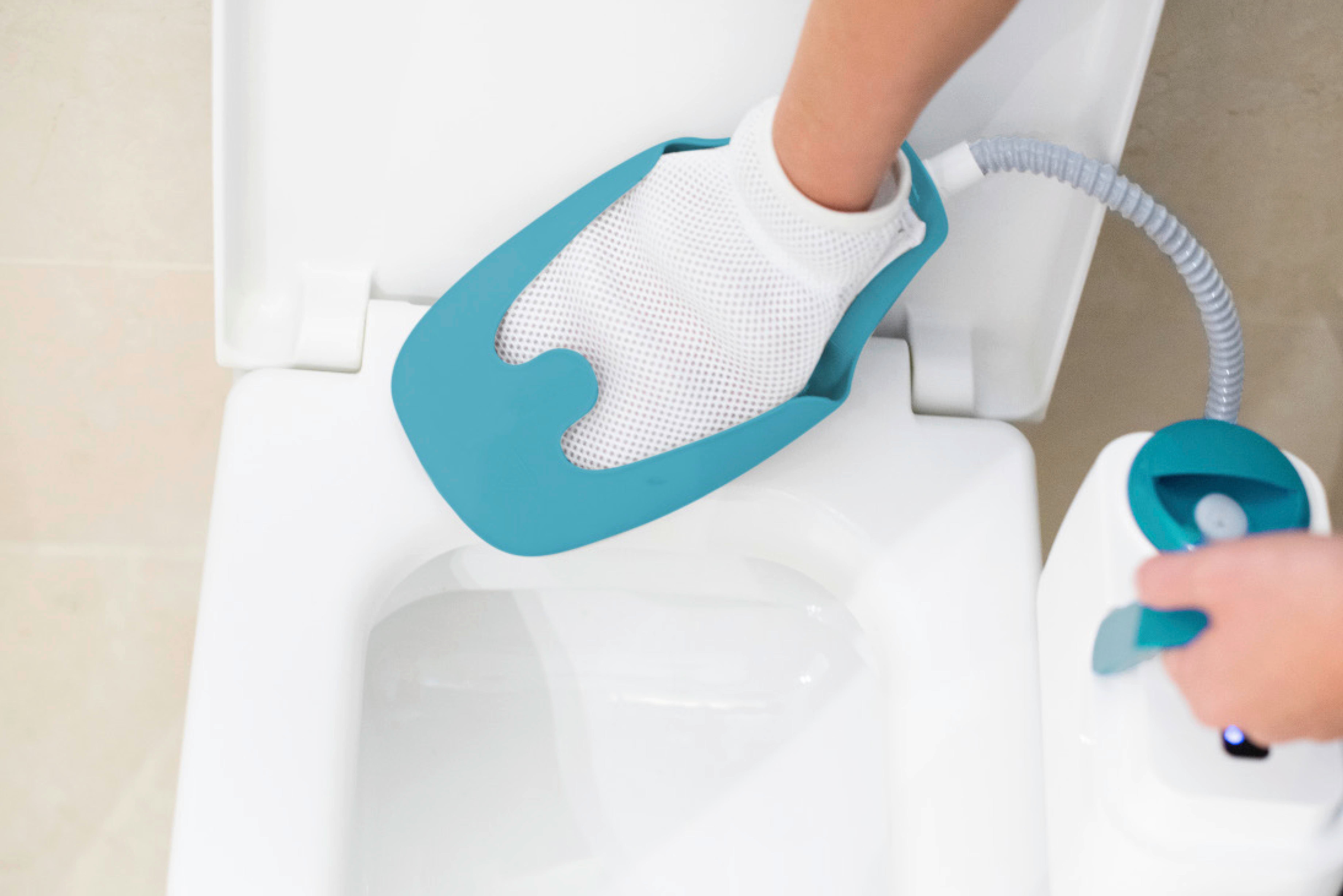 Eine Hand hält einen Reinigungshandschuh über einer weißen Toilette, mit einem Reinigungsgerät in der Nähe.