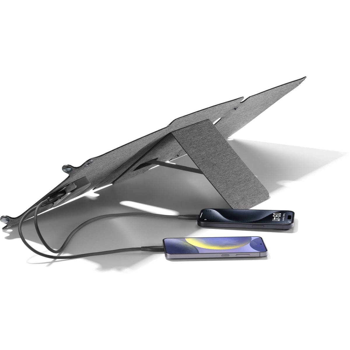 Supporto di ricarica grigio con due telefoni collegati. Entrambi i telefoni sono neri con gli schermi accesi.
