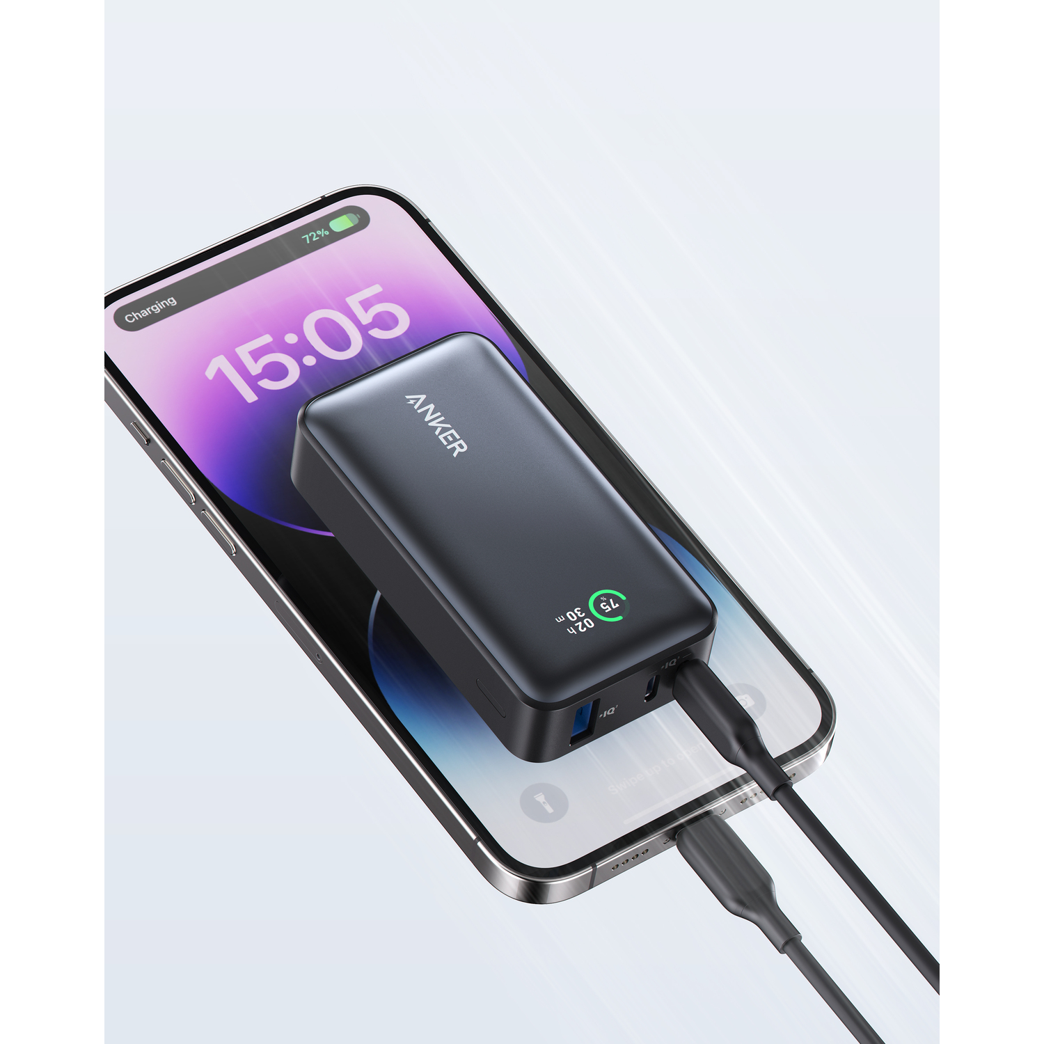 Une batterie externe Anker noire chargeant un téléphone. Le téléphone affiche l'heure et le pourcentage de batterie.