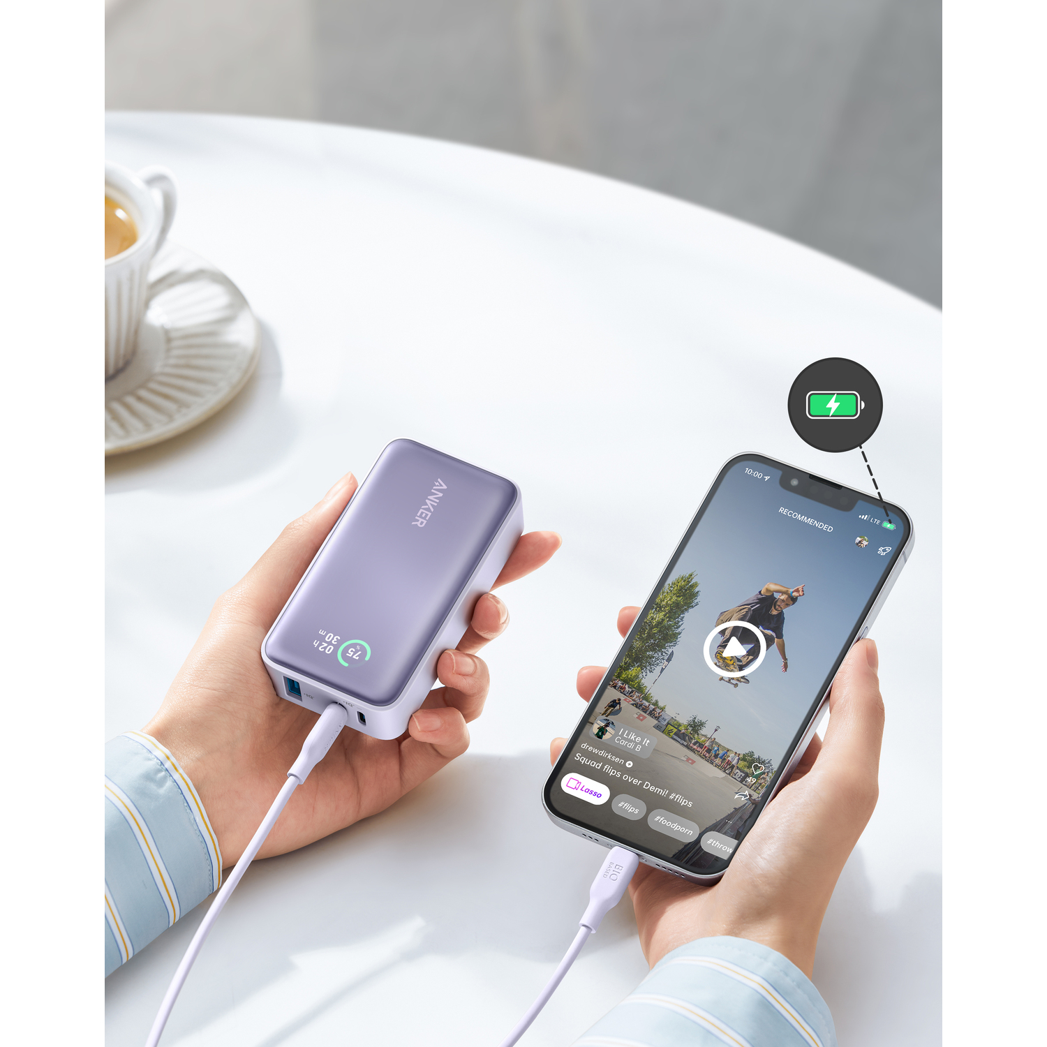 Mains tenant un téléphone et une batterie externe reliés par un câble.