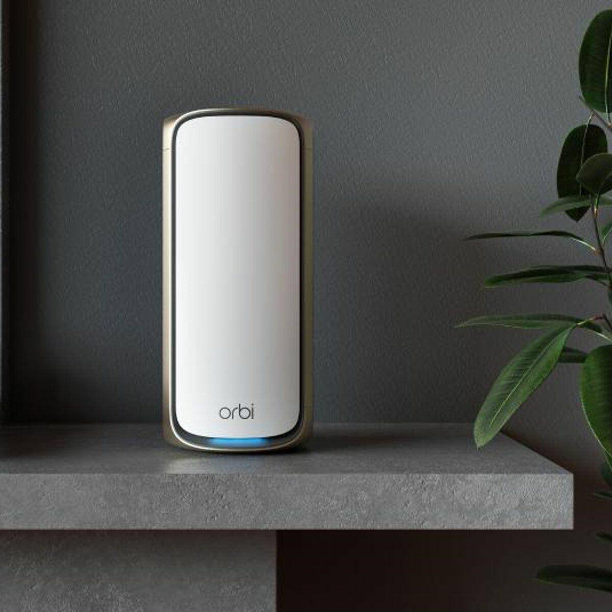 Ein weißes Orbi Mesh-WLAN-Gerät steht auf einem grauen Regal vor einer dunklen Wand.