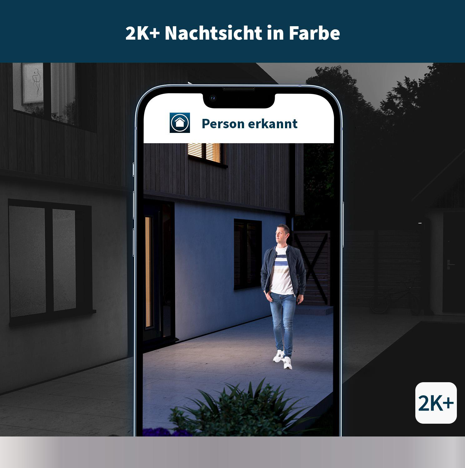 Ein Mann ist nachts auf einem Telefonbildschirm zu sehen. Häuser sind im Hintergrund.
