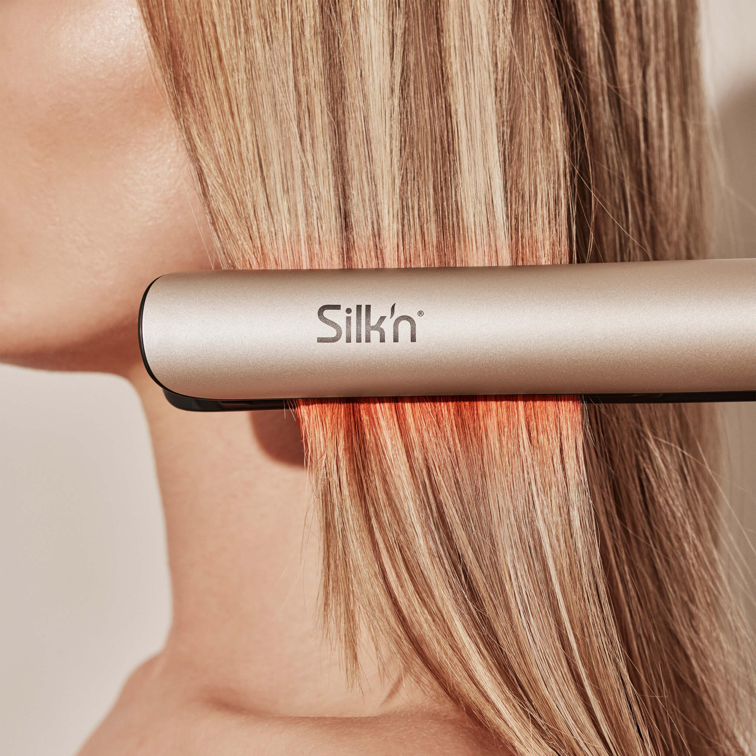 Blondes Haar wird mit einem goldenen Silk'n Haarglätter geglättet.