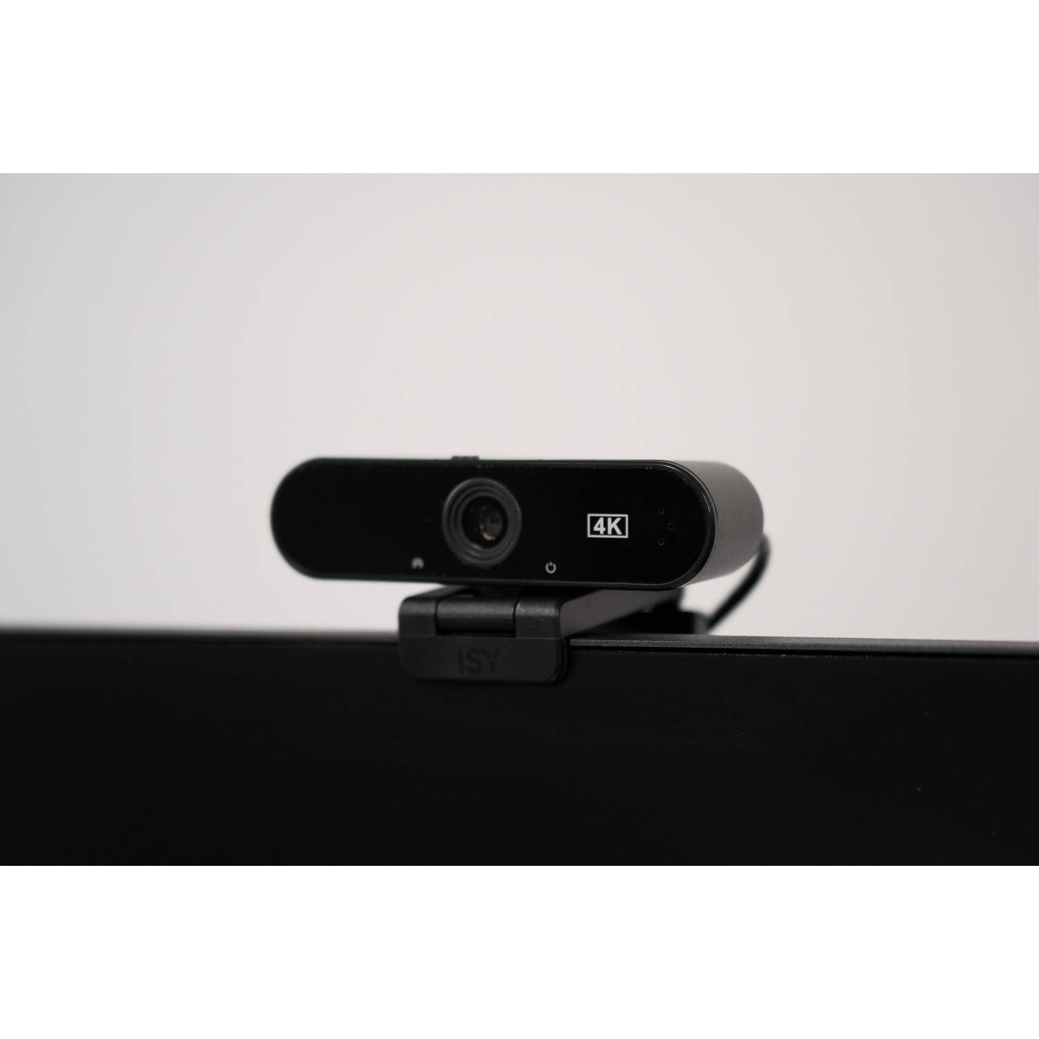 Une webcam 4K noire montée sur un moniteur noir.