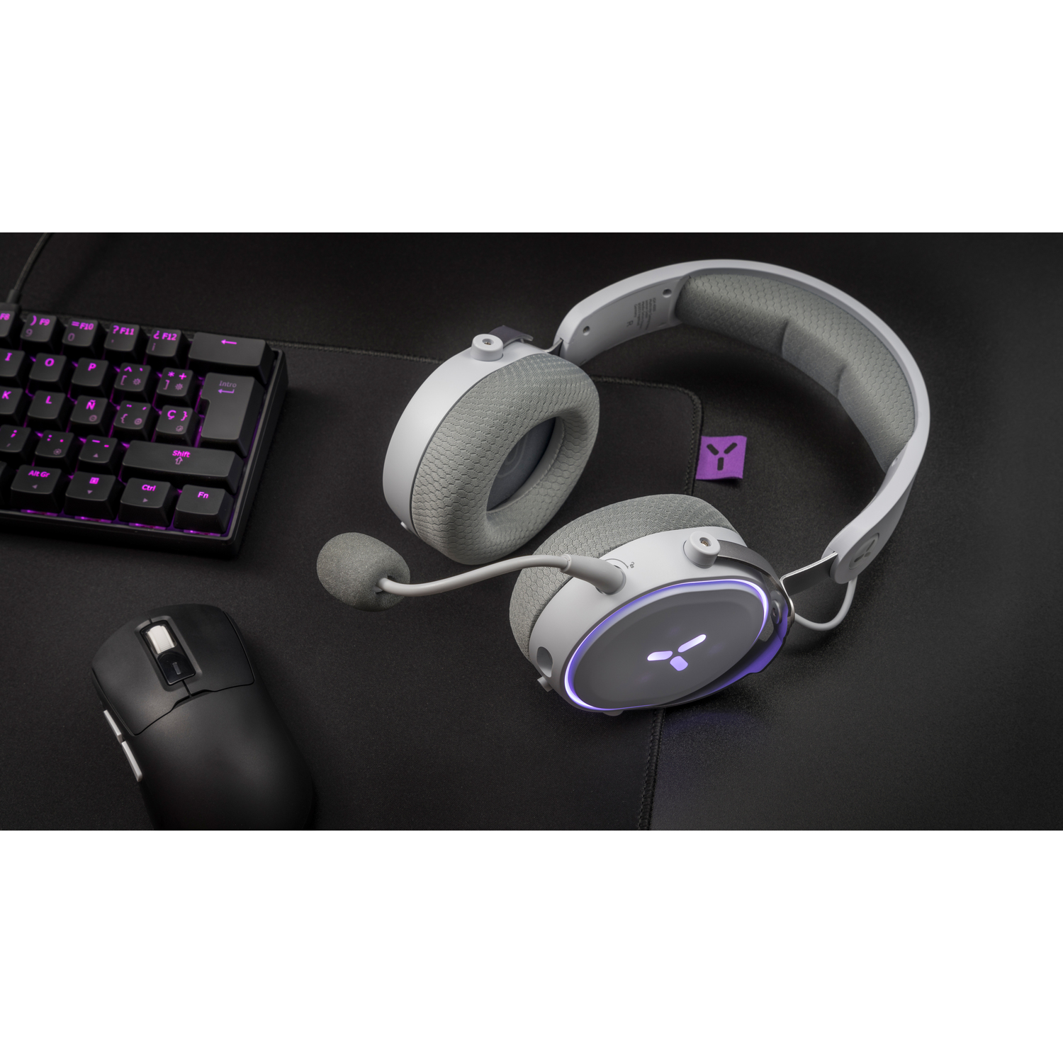 Black headset and mouse on a black surface, keyboard in the background.
