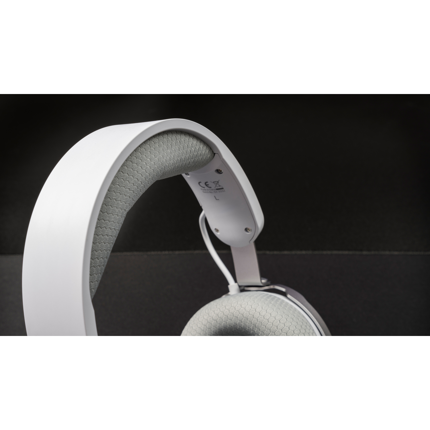 White and gray headphones on a black background. The headband is visible.