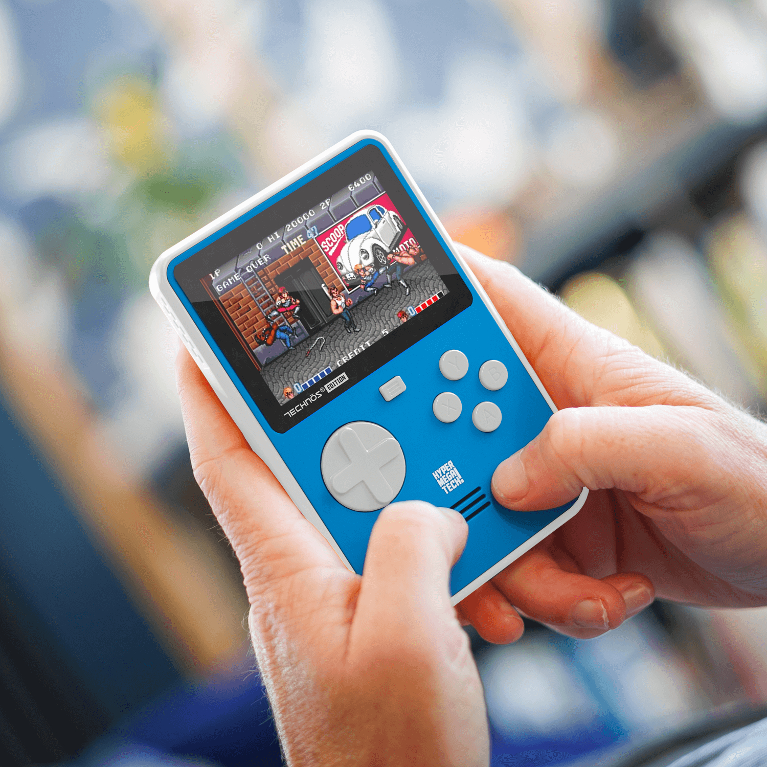Eine Person hält eine blau-weiße Handheld-Spielekonsole. Ein Spiel ist auf dem Bildschirm zu sehen.