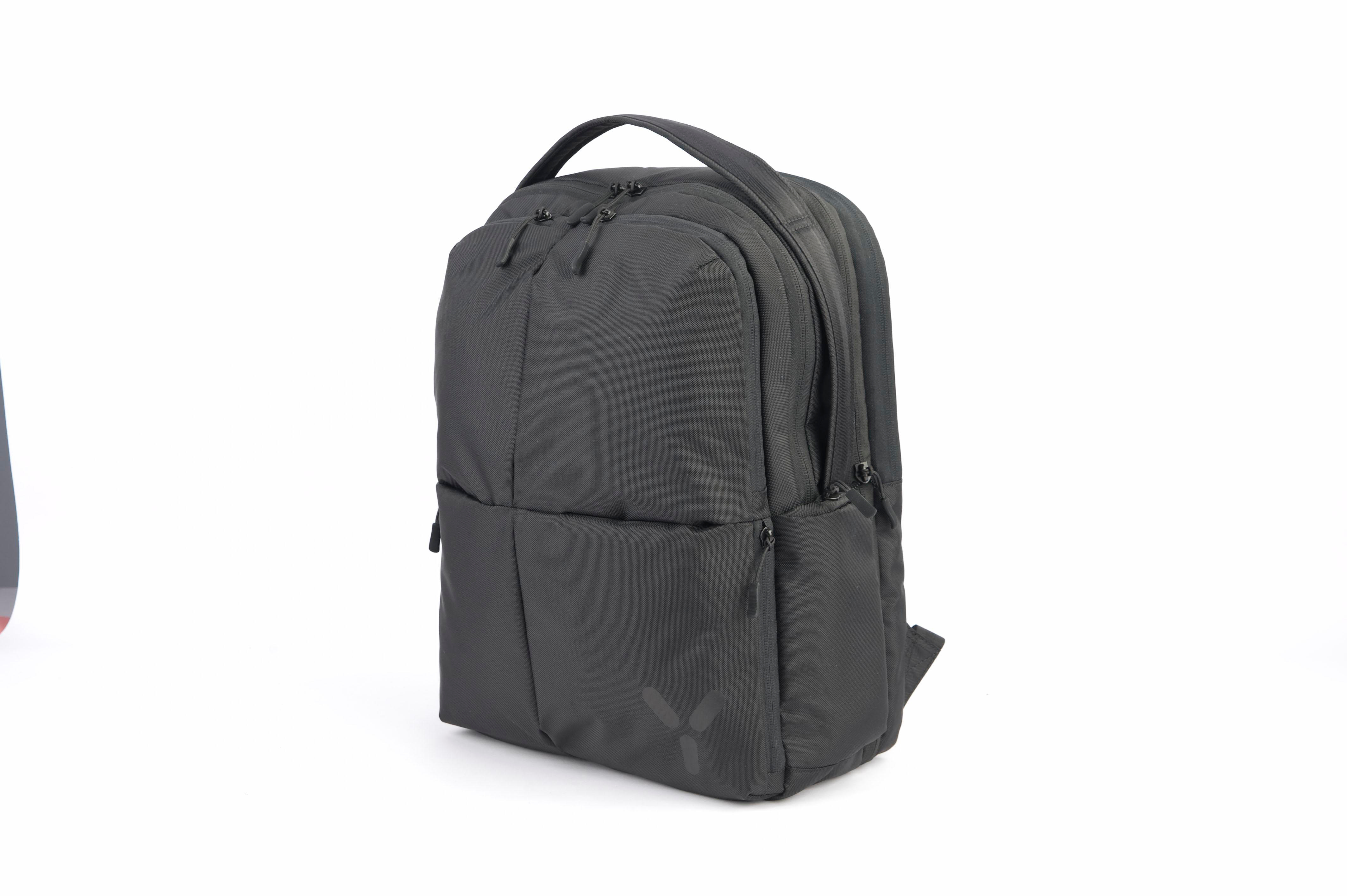 Schwarzer Rucksack auf weißem Hintergrund. Mit Griff, Reißverschlüssen und Logo.