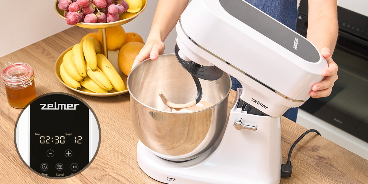 Kobieta używa białego miksera. Minutnik pokazuje 02:30, prędkość 12. Owoce z boku.