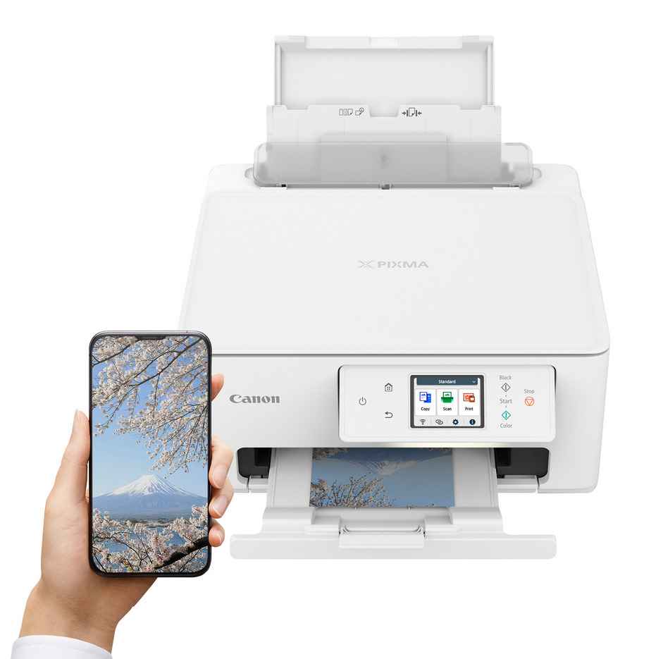 Ein Canon-Drucker neben einem Telefon, das ein Foto eines Berges zeigt.