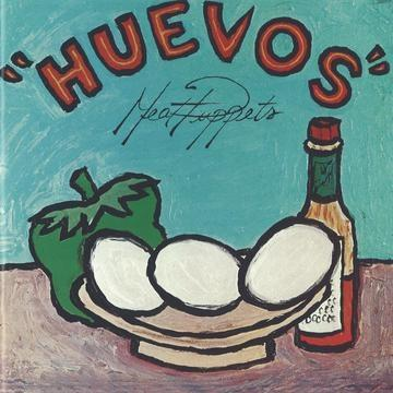 Kunstwerk met eieren, een groene paprika en een fles. Het woord 'HUEVOS' staat bovenaan.