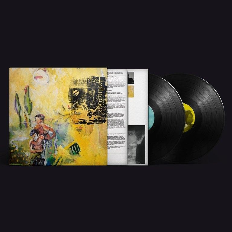 Albumcover mit Artwork, das Figuren und Landschaft zeigt. Zwei Vinylplatten liegen neben dem Cover.