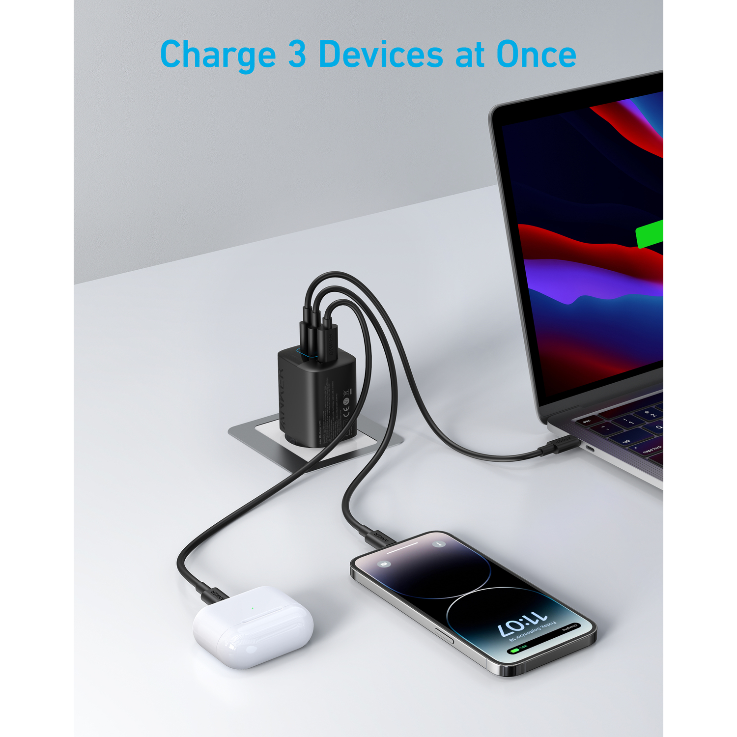 Black charger charging a phone, earbuds, and a laptop. Text: Charge 3 Devices at Once.