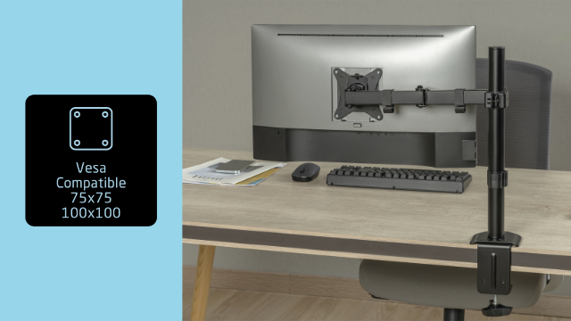 Monitor op een bureau met een monitorarm. Een Vesa-compatibele doos staat links, bureau op de achtergrond.