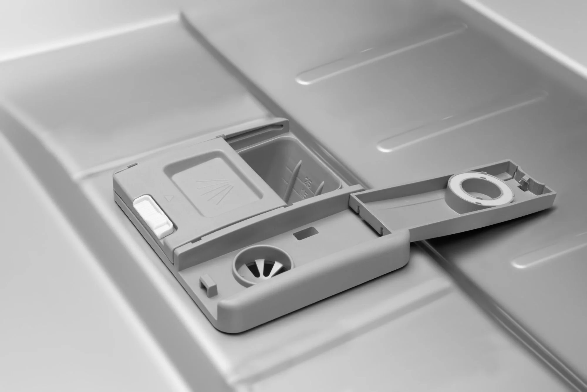 Zbliżenie, szary dozownik detergentu do zmywarki. Otwarta komora.